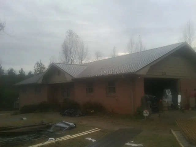 Gray metal roof on a stucco house with an attached garage in Saint Lucas