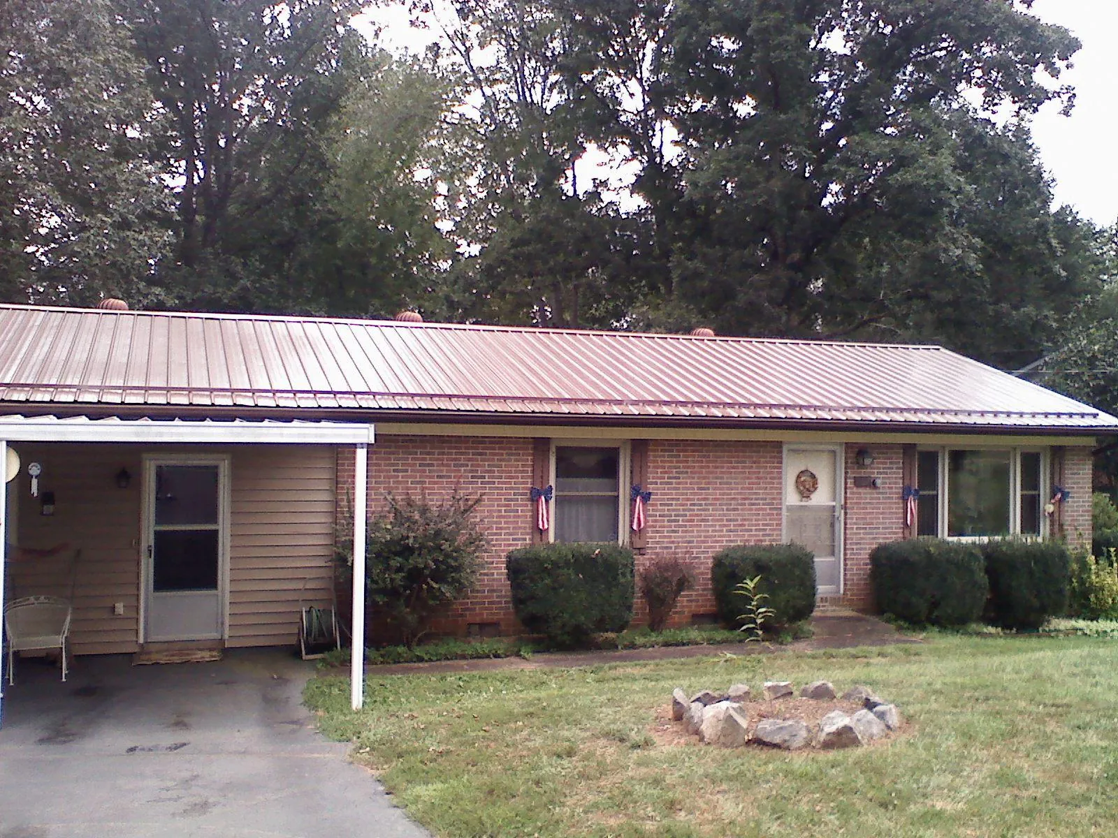 Bronze metal roof and carport on a brick ranch home — Roof Repair work by our crew in Saint Lucas